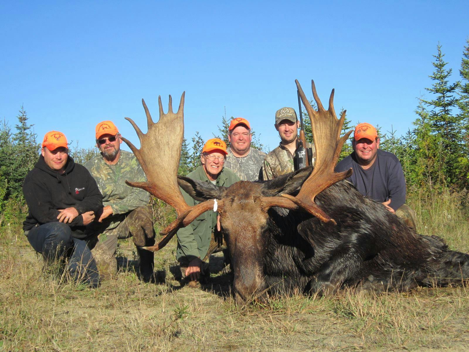 Image of a group of men sitting around an animal they hunted